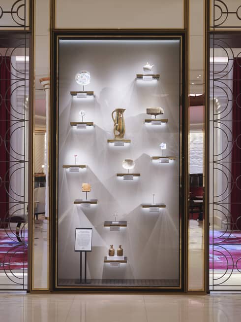 Vertical, lit wall display of 12 artefacts