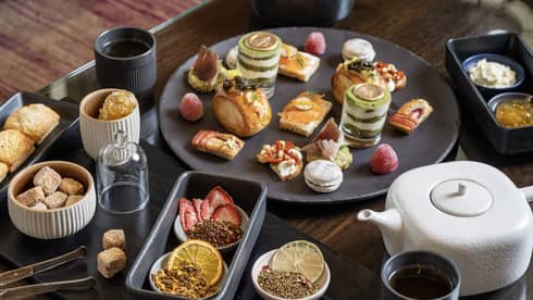 Various foods on a plate with a tea kettel.