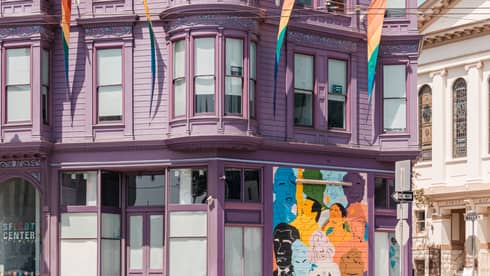 A light purple building on a street corner.