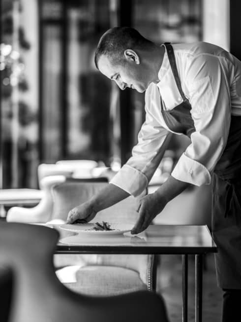Shot of Chef Alan Taudon setting a plate on a table for two