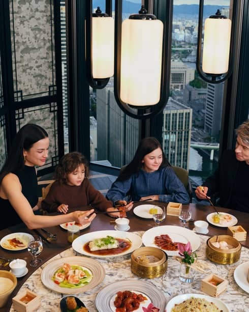A family fines at fine dining restaurant with city view