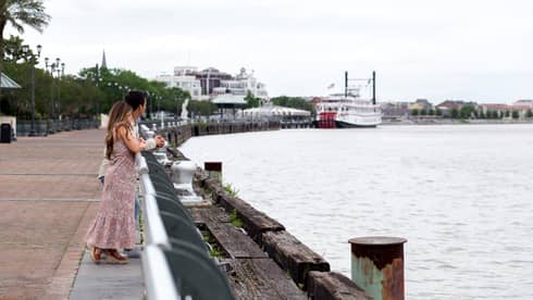 A woman and man looking out a river.