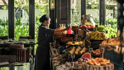 Cafe Nam Hai server reaches for jugs of fresh juice on brunch buffet
