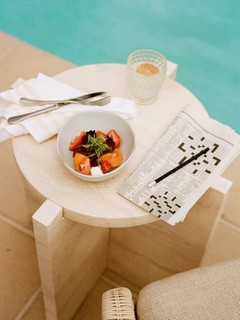 Poolside fruit dish and crossword puzzle