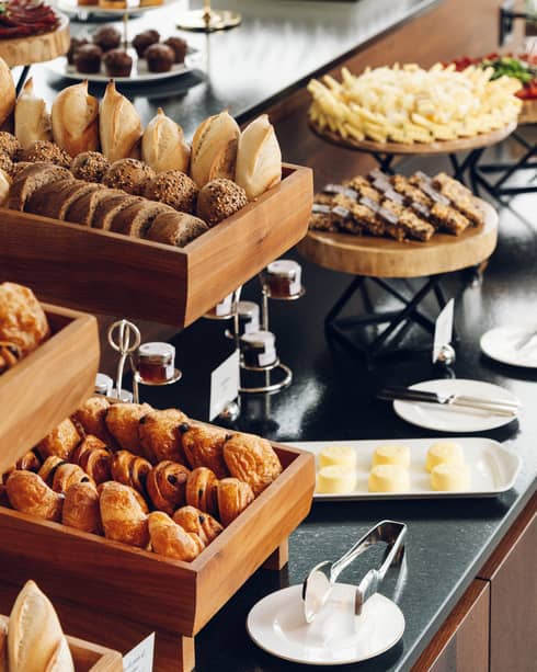 Display shelves with a variety of pastries, sweets and other baked goods on trays, plates and display stands
