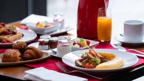 Bed and breakfast setup with croissants, waffles, fresh fruit, yoghurt and orange juice at Four Seasons
