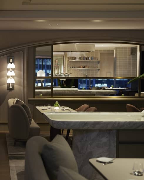 Dining room at S�ZANNE intimately lit, show kitchen visible in background