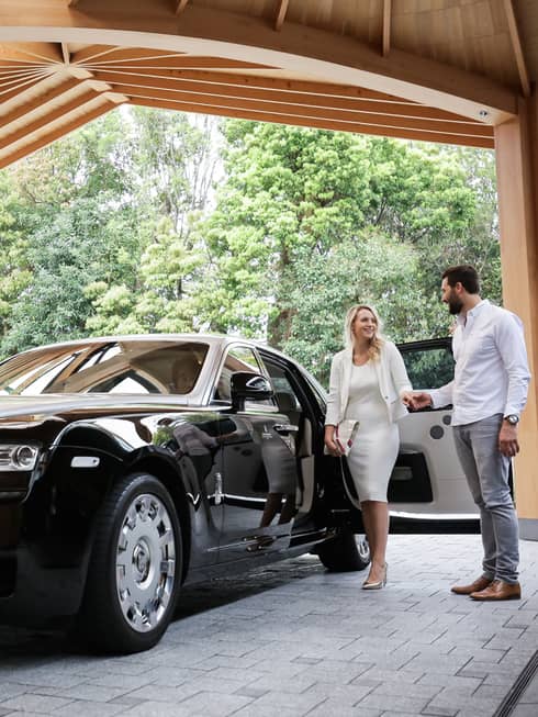 Couple exits black Bentley under awning at Four Seasons Hotel Kyoto