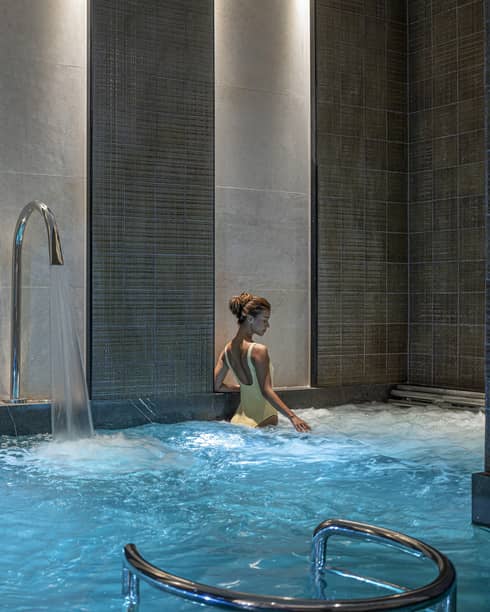 Woman in yellow bathing suit soaks in the Spa's vitality pool
