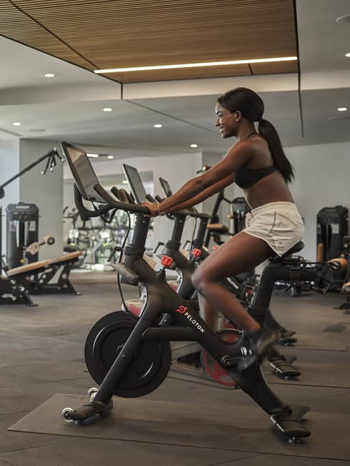 A woman on a stationary bike in a gym.