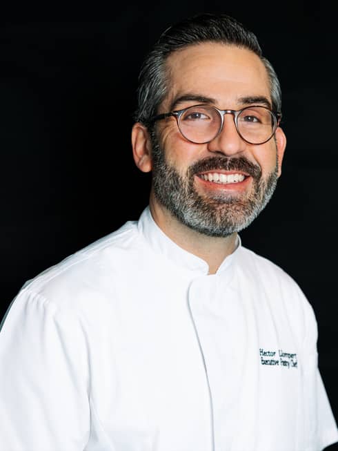 Chef Hector Llompart smiling and wearing a chef's uniform.
