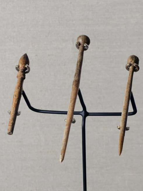 Three bone hairpin artefacts on display stand