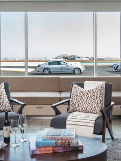 Private airport Suite seating area, car and runway in background through window