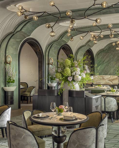 Stylish interiors of Chinese restaurant Song, with turquoise carpet and walls, arched entryways into dining areas and modern lighting fixture, Four Seasons Hotel Hangzhou at Hangzhou Centre