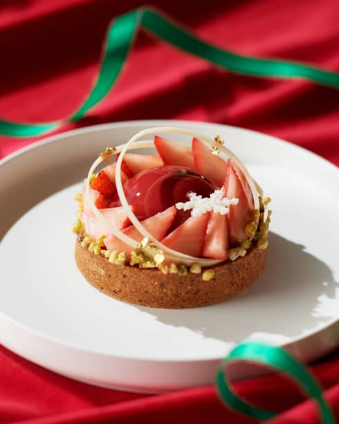 A tart with strawberries on a white plate.
