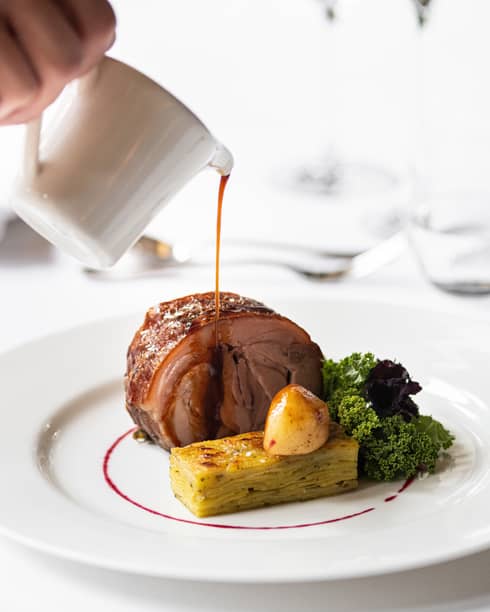 Roast pork with el gratin potato, sauce drizzled over top