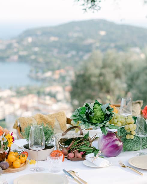 Elegantly set dining table with produce d�cor overlooking the Mediterranean Sea
