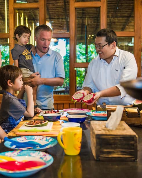 Chef presents two halves of dragon fruit to family during Thai cooking demonstration