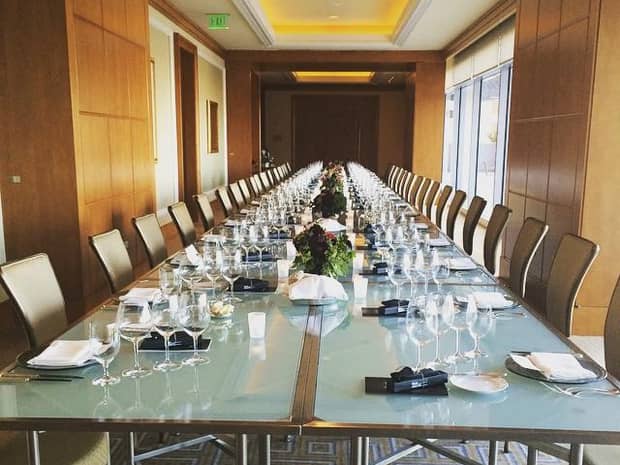 Long frosted glass boardroom table in modern meeting room with wood panel walls