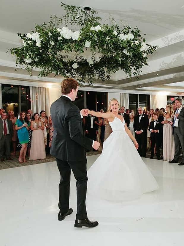 Bride and groom enjoy wedding dance as guests look on