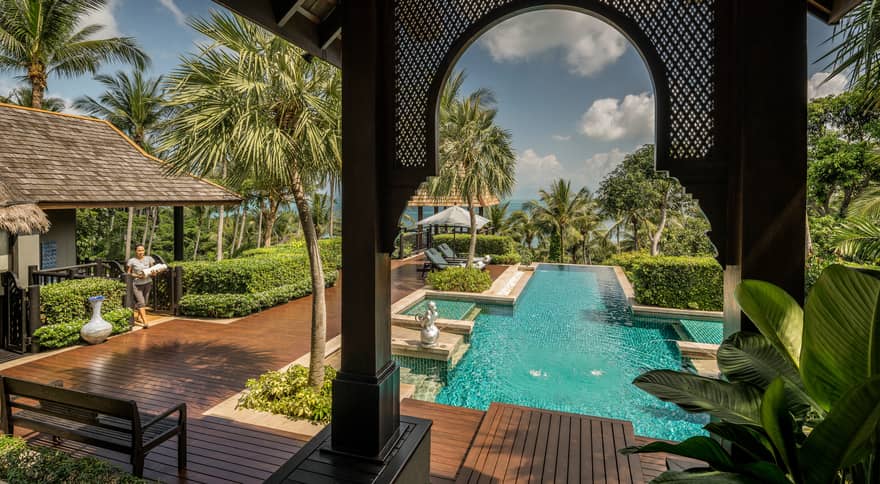 View from arched pergola to long outdoor swimming pool, sunny deck