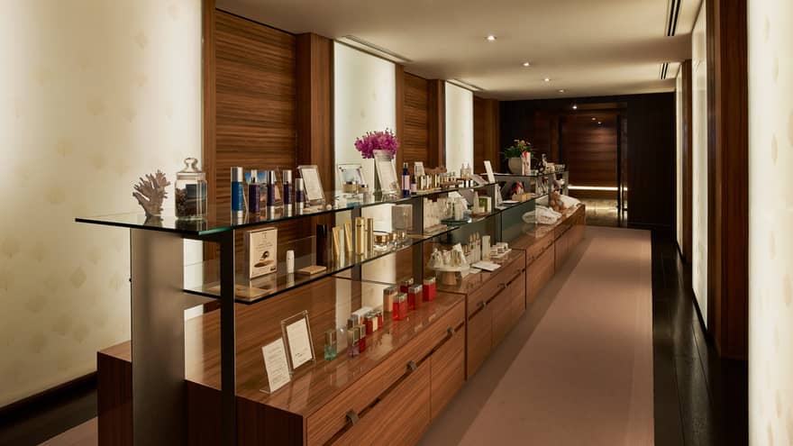 Wood and glass display shelves with boutique items in dimly lit hallway