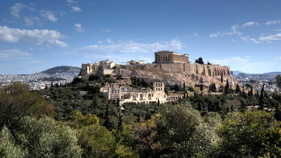 Ancient ruins of Acropolis on mountain surrounded by greenery