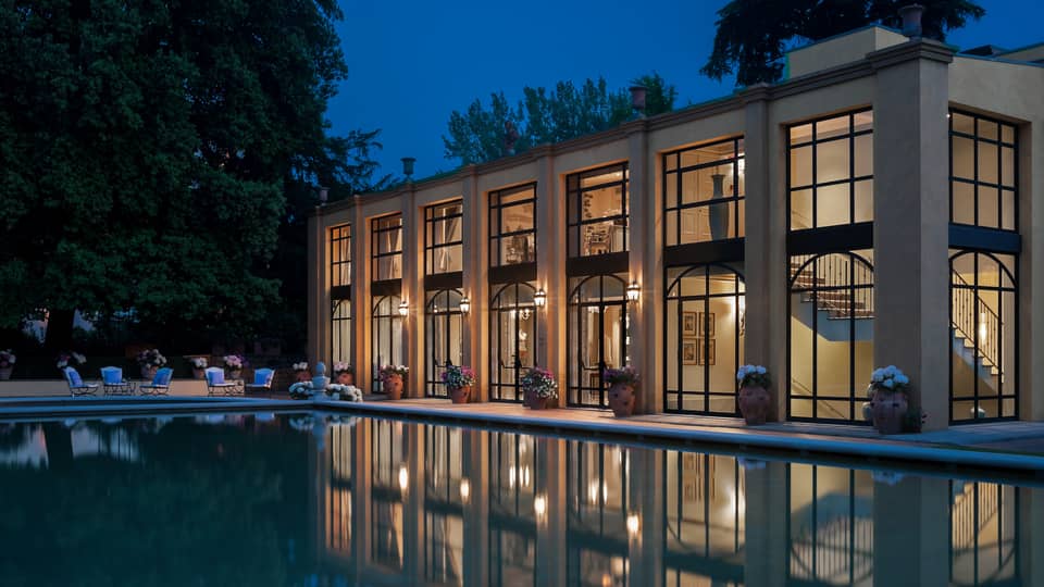Four Seasons Hotel Florence two-level exterior with large picture windows overlooking pool at night