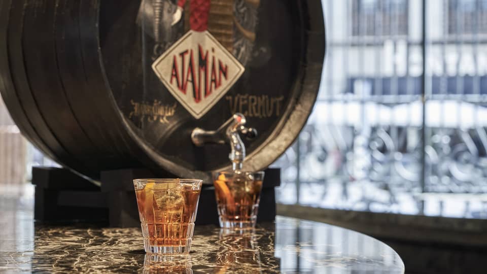 Vermouth cask with two filled cocktail glasses on marble table
