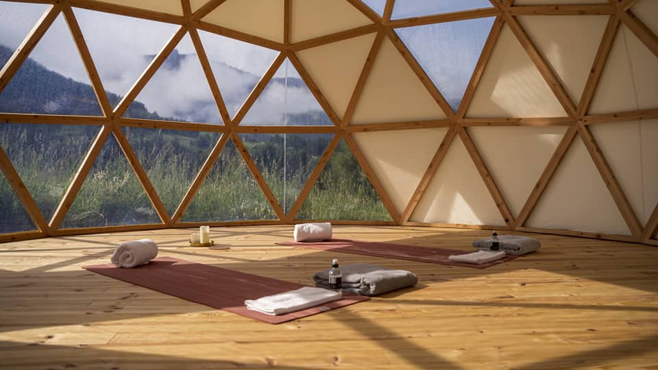 Spa studio set with two yoga mats and mountain view outside hive-like windows