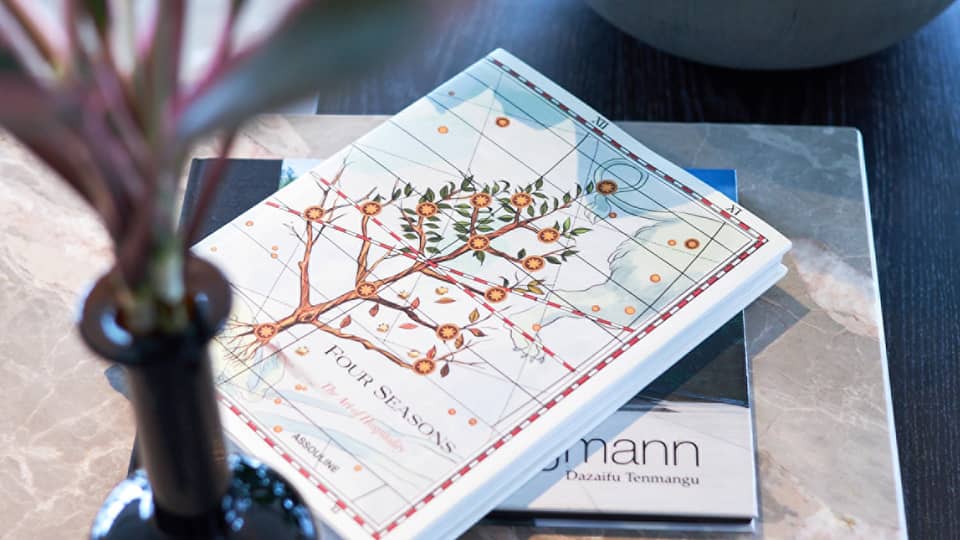 Four Seasons hotel book with an illustrated cover featuring a flowering tree on a table