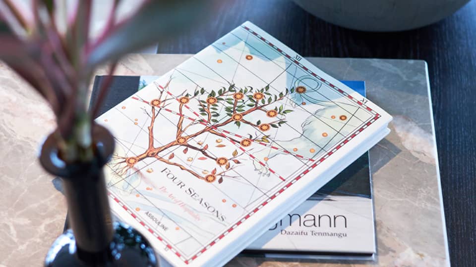 Four Seasons hotel book with an illustrated cover featuring a flowering tree on a table
