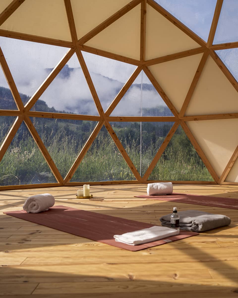 Spa studio set with two yoga mats and mountain view outside hive-like windows