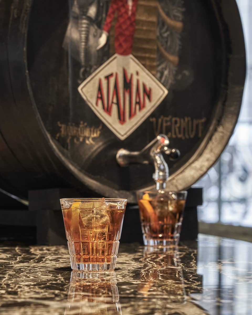 Vermouth cask with two filled cocktail glasses on marble table