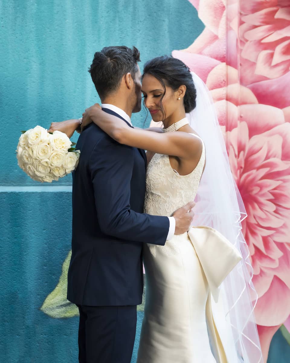 A woman in a wedding dress holding a man in a suit.