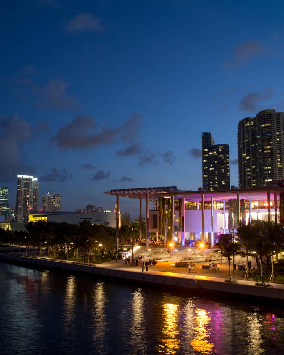 Building with colourful lights at night along water