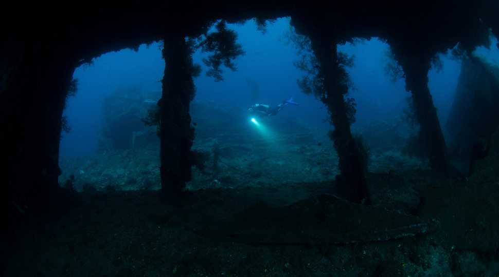 Divers explore a WWII shipwreck of the coast of Bali