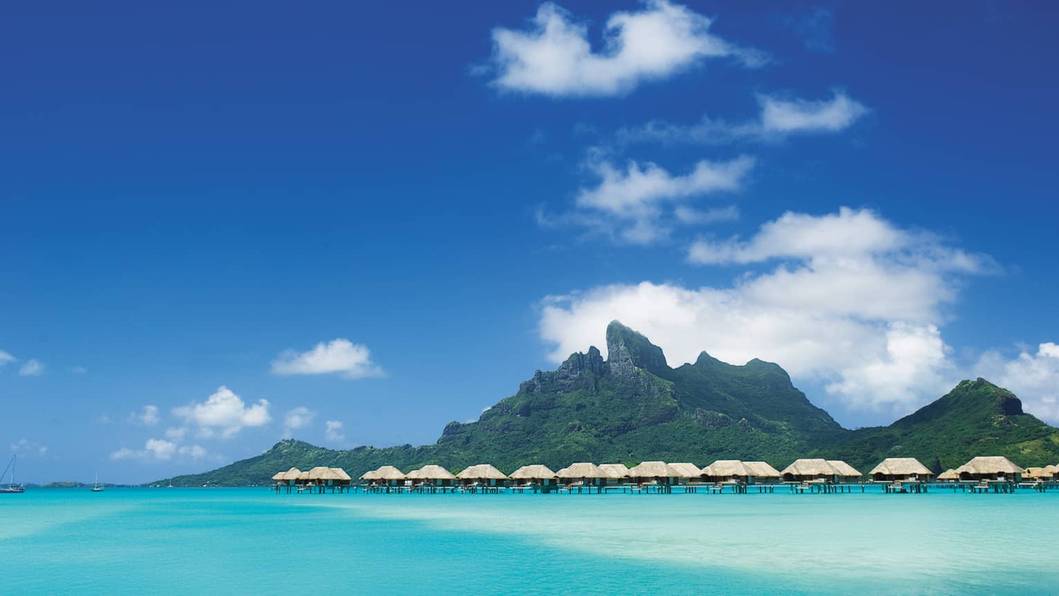 Island and row of overwater bungalows along lagoon