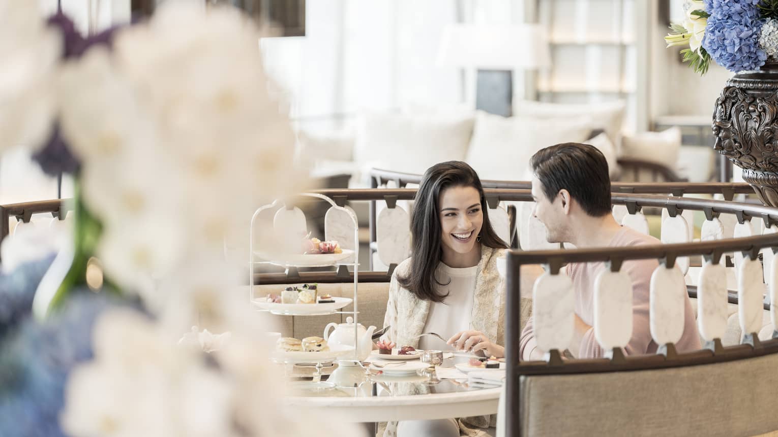 Smiling couple enjoys Afternoon Tea at the Lobby Lounge in round booth